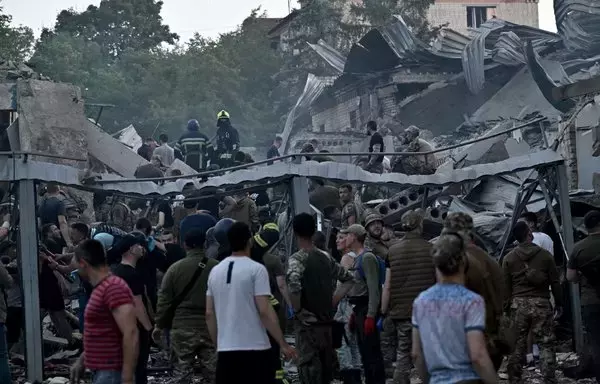 
Rescatistas y voluntarios trabajan para rescatar a las víctimas debajo de los escombros después de que un misil ruso impactara en un restaurante y varias casas en Kramatorsk, Ucrania, el 27 de junio. [Genya Savilov/AFP]        