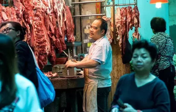 
En Hong Kong carniceros trabajan al aire libre en sus puestos. Las exportaciones de Brasil, el principal exportador mundial de carne de res y aves, cayeron en la primera mitad de 2023, por la imposición de restricciones impulsada por China. [Jayne Russell/AFP]        