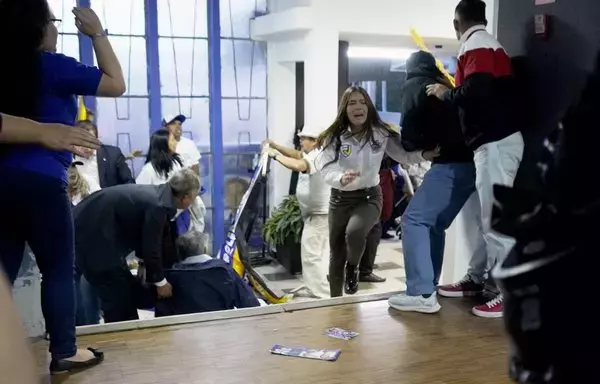 People take cover after shots were fired at the end of a campaign rally for Ecuadoran presidential candidate Fernando Villavicencio in Quito on August 9. Villavicencio was assassinated 'hitman-style and with three shots to the head,' the country's main newspaper, El Universo, reported. [AFP]