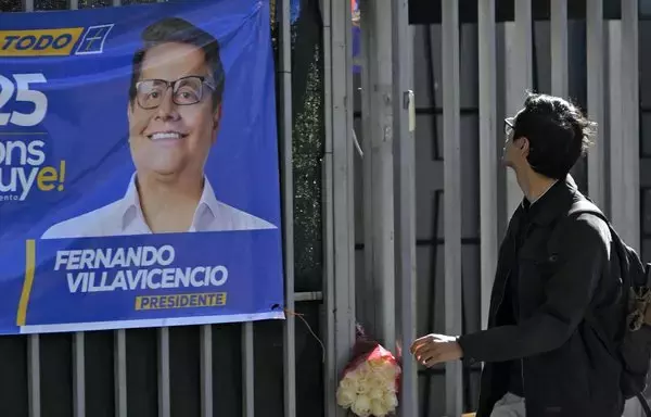 A man looks at a banner depicting Ecuadoran presidential candidate Fernando Villavicencio on the railings of the sports complex in Quito where he was assassinated on August 9. [Rodrigo Buendía/AFP]