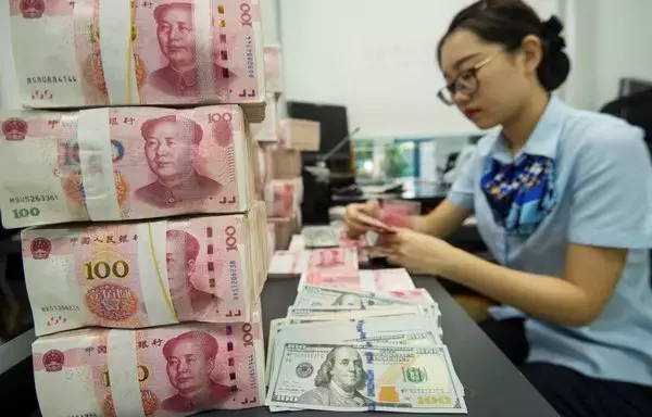 
Un empleado de un banco chino cuenta billetes de 100 CNY y billetes de dólares estadounidenses en un mostrador de un banco en Nantong, provincia de Jiangsu. El gobierno boliviano empezó a tomar medidas para utilizar el yuan y atraer un banco chino a Bolivia en respuesta a una grave escasez de dólares desde los principios de 2023. [AFP]        