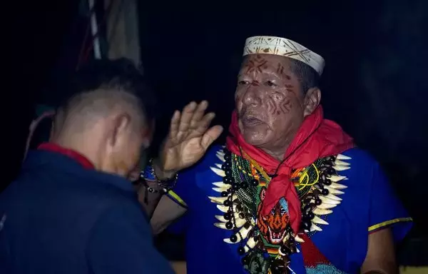 Isidro Lucitante (derecha), curandero de la etnia indígena cofán, participa en una ceremonia de consumo de Yage (Ayahuasca) en el pueblo de Avie, en Lago Agrio, provincia de Sucumbíos, región amazónica ecuatoriana. Tras una consulta popular celebrada el 20 de agosto, Ecuador anunció la decisión histórica de detener la explotación de petróleo en el Parque Nacional Yasuní y prohibir toda explotación minera en el Chocó Andino. [Pedro Pardo/AFP]