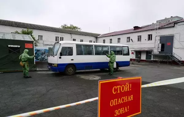 
Militares rusos con equipo de protección desinfectan un autobús para reclutas en una oficina de reclutamiento en la ciudad de Vladivostok, en el extremo oriente. [Pavel Korolyov/AFP]        