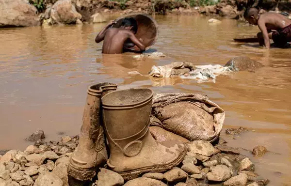 
Se ven un par de botas de goma y otras herramientas utilizadas en una mina a cielo abierto mientras niños mineros venezolanos trabajan en el barro en busca de oro en El Callao, estado Bolívar, Venezuela. En El Callao, extraer oro del suelo comienza como un juego de niños, pero pronto se convierte en un trabajo de tiempo completo. [Yris Paul / AFP]        