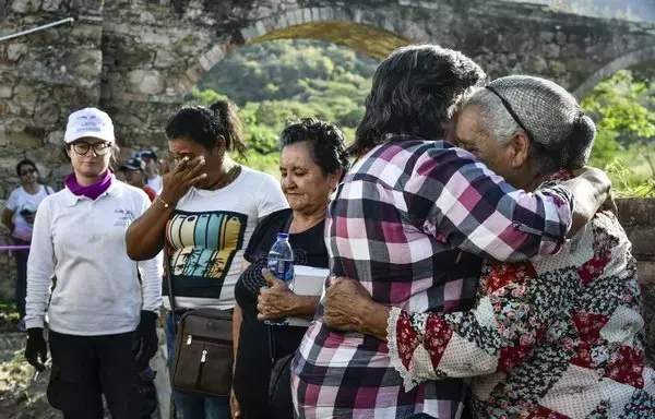 
Familiares de las víctimas se reúnen afuera de las cámaras de cremación, donde las víctimas fueron desaparecidas por grupos paramilitares durante el conflicto armado. Esta sombría escena se desarrolla en Juan Frío, ubicado en el municipio de Villa del Rosario, cerca de la frontera entre Colombia y Venezuela, capturado el 27 de septiembre. [Schneyder Mendoza / AFP]        