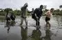 
Migrantes cruzan el río Tuquesa cerca de la aldea de Bajo Chiquito, el primer puesto de control fronterizo de la provincia de Darién, Panamá, en septiembre. El viaje clandestino por el Tapón del Darién suele durar cinco o seis días, a merced de malas condiciones climáticas. [Luis Acosta/AFP]        