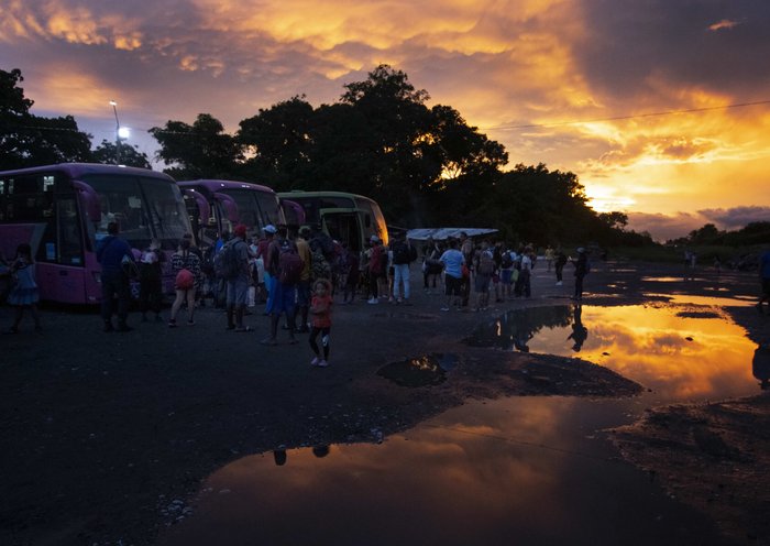 Migrantes venezolanos esperan abordar un autobús que los llevará a la frontera con Nicaragua en el campamento de refugiados de Paso Canoas en Puntarenas, Costa Rica. [Ezequiel Becerra / AFP]