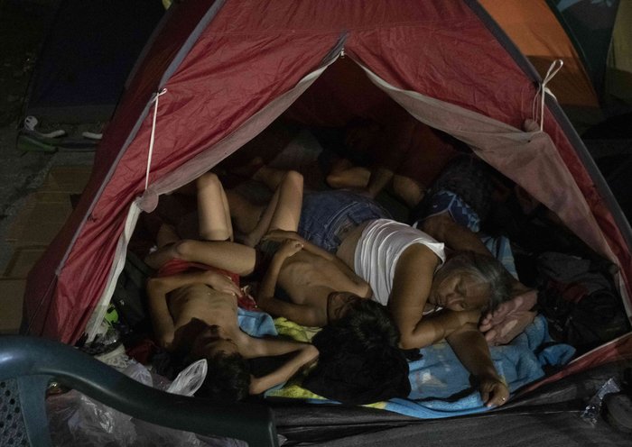 Una familia de inmigrantes duerme en un refugio improvisado en Paso Canoas, a unos 300 kilómetros al sur de San José, Costa Rica. [Ezequiel Becerra / AFP]