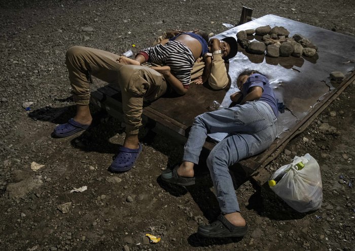 Una familia de inmigrantes venezolanos duerme en un refugio improvisado en Paso Canoas, a unos 300 kilómetros al sur de San José, Costa Rica. [Ezequiel Becerra / AFP]