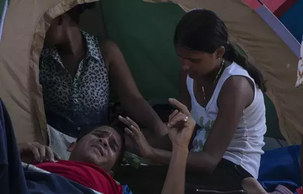 
Una niña migrante toca la cabeza adolorida de su padre en el campo de refugiados de Paso Canoas en Puntarenas, Costa Rica. Paso Canoas, el principal paso fronterizo entre Panamá y Costa Rica, se ha convertido en una encrucijada para los migrantes. [Ezequiel Becerra / AFP]        