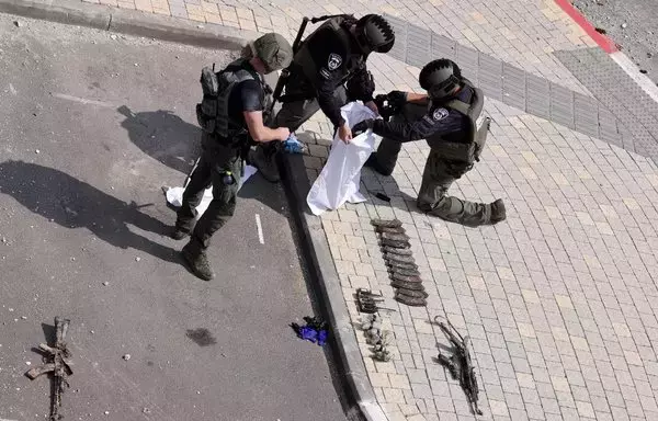 Soldados israelíes inspeccionan las armas utilizadas por sus enemigos frente a una comisaría israelí en Sderot, el 8 de octubre, tras las batallas para desalojar a los militantes de Hamás que estaban asentados en su interior. [Jack Guez/AFP]