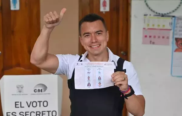 El presidente electo de Ecuador, Daniel Noboa, se pone un chaleco antibalas mientras muestra orgulloso su voto en un colegio electoral en Olón, provincia de Santa Elena, Ecuador, el 15 de octubre. [Marcos Pin / AFP]