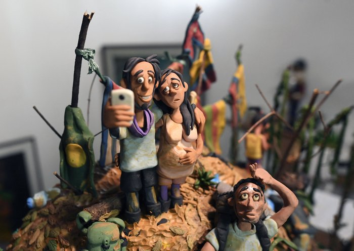 Un primer plano de la obra del artista colombiano Edgar Álvarez titulada "Loma de las Banderas" durante una entrevista en su estudio de Bogotá el 5 de octubre de 2023. Álvarez utiliza plastilina para representar las dificultades de los migrantes en América. Una de sus miniaturas retrata una escena habitual en la "Loma de las Banderas", un importante punto de partida para quienes emprenden el viaje de Colombia a Panamá a través de la peligrosa selva del Darién para llegar a Estados Unidos. (Foto de Daniel Munoz / AFP)