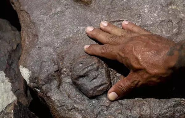 
El arqueólogo Jaime Oliveira, del Instituto Nacional del Patrimonio Histórico y Artístico, muestra antiguos grabados rupestres que reaparecieron debido a la grave sequía que afecta a la región, a orillas del río Negro, en la ciudad brasileña de Manaus. [Michael Dantas / AFP]        