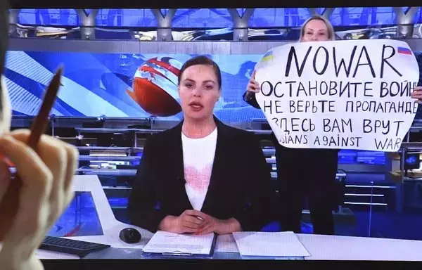 Una mujer mira la pantalla de la computadora mientras disidente Marina Ovsyannikova, que trabaja en Canal Uno ruso, entra en el estudio de televisión Ostankino en Moscú el 15 de marzo de 2022, durante el noticiario vespertino más visto de Rusia. [Alexander Nemenov/AFP]