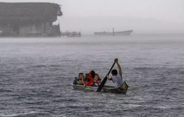 Por la belleza de la isla de Carti Sugtupu, en Panamá, un indígena guna y su familia navegan hábilmente en su canoa. [Luis Acosta / AFP]