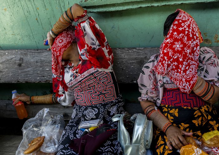 Mujeres indígenas Guna hacen bromas en la isla de Carti Sugtupu, donde cientos de residentes se preparan para un necesario traslado, en respuesta a la amenaza de la subida de las aguas, consecuencia de los efectos del cambio climático. [Luis Acosta / AFP]