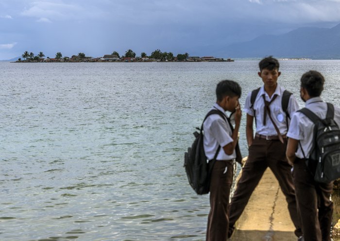 Estudiantes indígenas Guna conversan antes de asistir a clase en la isla de Carti Sugtupu. [Luis Acosta / AFP]