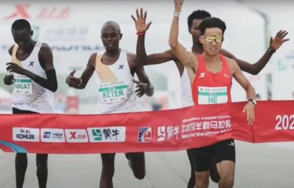 En una captura de pantalla de un vídeo de YouTube, tres corredores africanos permiten deliberadamente que el chino He Jie gane el medio maratón de Pekín. El video contenía imágenes ampliamente compartidas en línea de la carrera del 14 de abril.