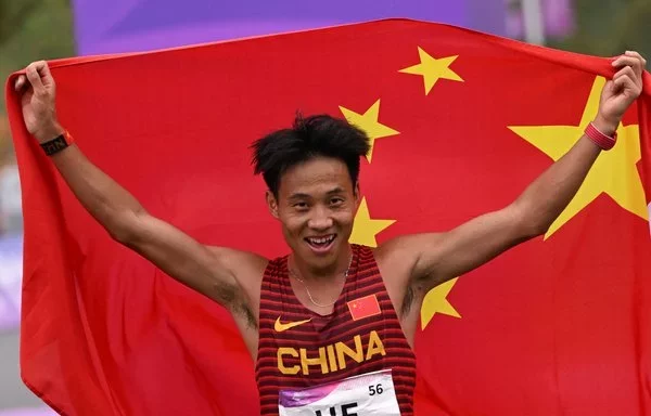 
Gold medalist He Jie of China celebrates following the conclusion of the men's marathon final during the 2022 Asian Games in Hangzhou, Zhejiang province, China. [William West/AFP]        