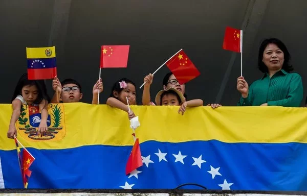 
Niños chinos ondean banderas a la llegada del barco hospital chino Arca de la Paz al puerto de La Guaira, Venezuela, el 22 de septiembre de 2018. [Federico Parr/AFP]        