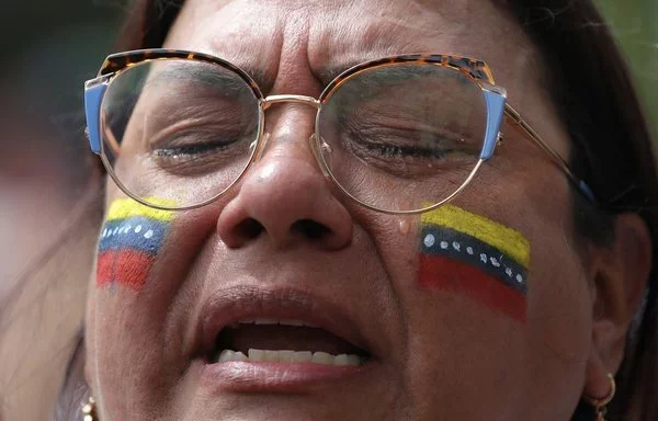 Una mujer llora frente al consulado venezolano en Medellín, Colombia, el 28 de julio. [Jaime Saldarriaga/AFP]