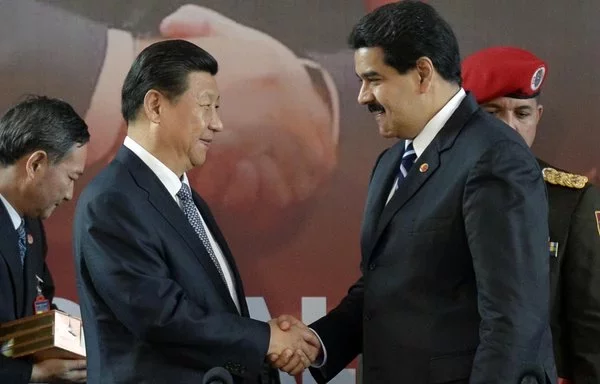 
El presidente venezolano, Nicolás Maduro (derecha), da la mano al presidente chino, Xi Jinping, en Caracas en julio de 2014. [Leo Ramírez/AFP]        