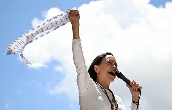 
La líder de la oposición venezolana María Corina Machado habla a sus seguidores mientras sostiene actas electorales durante una manifestación en Caracas, el 28 de agosto. [Juan Barreto/AFP]        