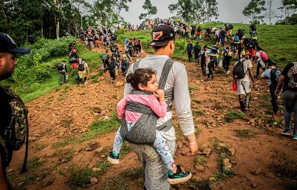 
Un padre lleva a su hija en su espalda mientras cruza el traicionero Tapón del Darién. [Médicos Sin Fronteras]        