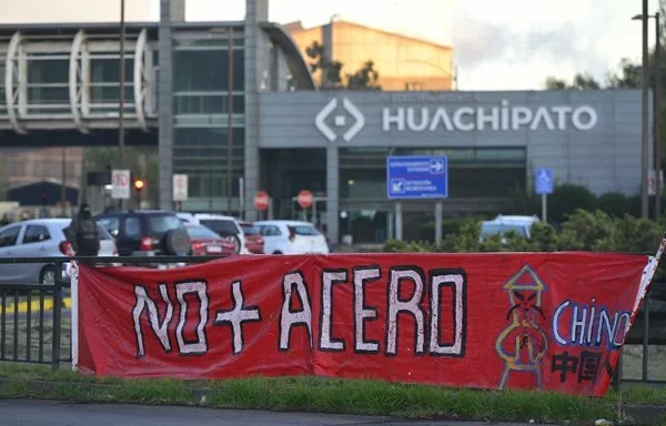 Un cartel en el que se lee "Basta de acero chino" se exhibe durante una protesta de trabajadores del acero contra el cierre de la planta Huachipato, en Talcahuano, Chile. [Guillermo Salgado/AFP]