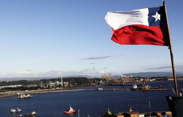 
Una bandera chilena ondea con la Siderúrgica Huachipato al fondo en Talcahuano, Chile. La mayor siderúrgica de Chile que cerró el 16 de septiembre, citando la competencia "desleal" del acero chino. [Maribel Fornerod/AFP]        