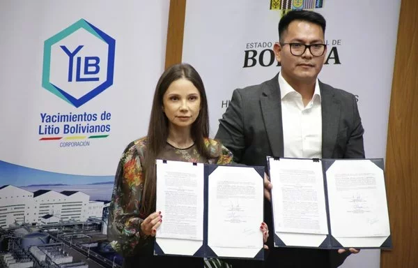 La representante de Uranium One Group, Larisa Lysova, y el presidente de YLB, Omar Alarcón, posan para los fotógrafos tras la firma de un contrato de extracción de litio por valor de 970 millones de dólares en Potosí. [Agencia Boliviana de Información (ABI)]