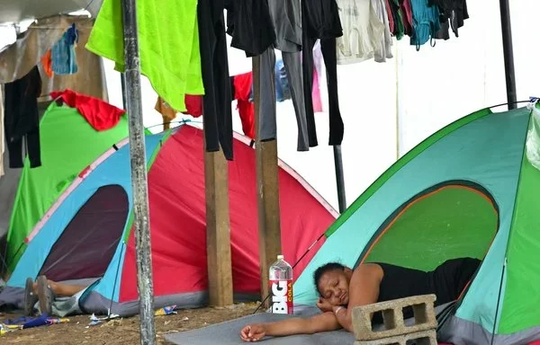 Los migrantes descansan en tiendas de campaña en el Centro de Recepción Temporal de Migrantes en Lajas Blancas, en la selvática provincia de Darién, 250 kilómetros al este de la ciudad de Panamá. [Martín Bernetti/AFP]