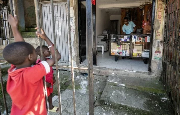 Franklin Mina trabaja en su papelería en Buenaventura, Colombia, uno de los mayores puertos del país y escenario de una feroz batalla entre pandillas. [Luis Acosta/AFP]