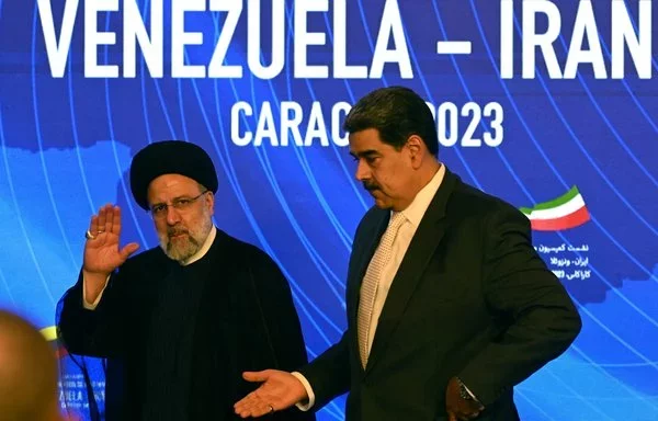 El entonces presidente iraní Ebrahim Raisi (izquierda) y el líder venezolano Nicolás Maduro saludan tras una conferencia de prensa conjunta en Caracas en junio de 2023. [Yuri Cortez/AFP]