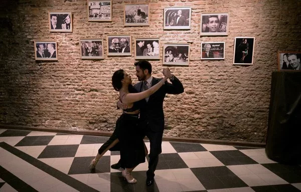 Los taxi dancers profesionales de tango David Tolosa y Laura Florencia Guardia posan para una fotografía durante una milonga en el icónico salón de tango Marabú en Buenos Aires. [Juan Mabromata/AFP]