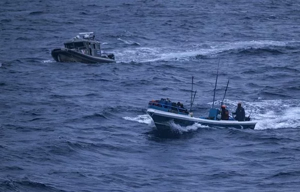 La Unidad de Reacción Rápida de Guardacostas de la Armada colombiana (izquierda) escolta una embarcación de bandera ecuatoriana en aguas del Pacífico colombiano el 8 de septiembre. La embarcación fue sorprendida transportando cinco tiburones martillo, sedosos y de aleta negra; 13 peces vela y cuatro marlines; 11 atunes y seis dorados. Tres pescadores fueron detenidos por faenar sin permiso en aguas extranjeras. [Luis Acosta/AFP]