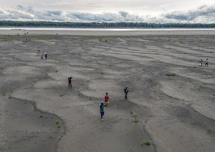 Vista aérea de los indígenas yagua transportando agua y otros bienes después de que gran parte del río Amazonas se secó en la isla de los Micos, departamento de Amazonas, Colombia. [Luis Acosta/AFP]