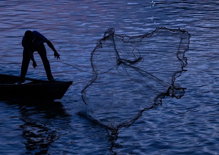 Un hombre pesca en el río Amazonas cerca de Puerto Nariño, Colombia. La Unidad Nacional para la Gestión del Riesgo de Desastres (UNGRD) de Colombia informó que el caudal del río ha disminuido hasta en un 90 % debido a una severa falta de precipitaciones que afecta a esta región de la triple frontera con Brasil y Perú, accesible solo por agua. [Luis Acosta/AFP]