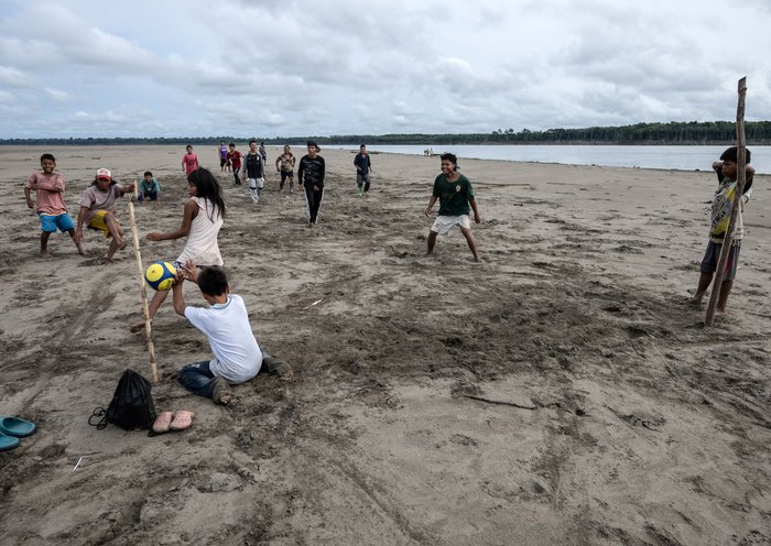 Los indígenas yagua juegan al fútbol a orillas del río Amazonas en la isla de los Micos, Colombia. [Luis Acosta/AFP]