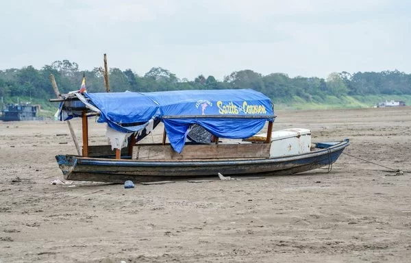 
Barcos permanecen varados por el bajo nivel del río Amazonas cerca de Leticia, Colombia. [Santiago Ruíz/AFP]        