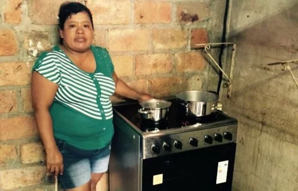 A woman poses with an induction cooker acquired through the Efficient Cooking Program (PCE) in Manabí province. [Efficient Cooking Program Coordination in Manta]