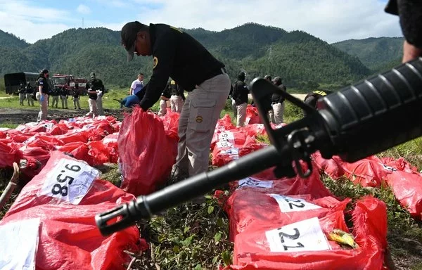 Miembros de la Agencia Técnica de Investigación Criminal (ATIC) de Honduras preparan paquetes de cocaína para ser incinerados en Tegucigalpa, Honduras. [Orlando Sierra/AFP]