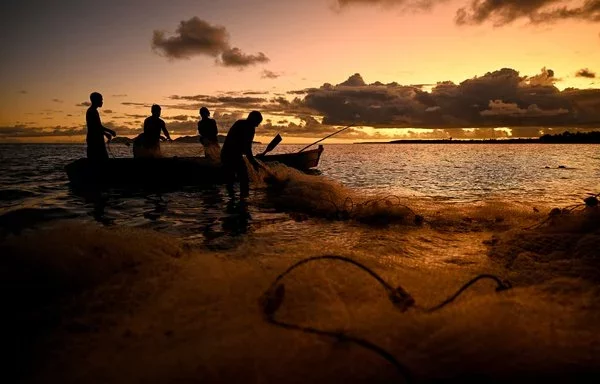 
Esta imagen muestra a miembros de una familia preparándose para pescar al atardecer en la ciudad costera de Toguru, a 35 kilómetros de la capital de Fiji, Suva. [Saeed Khan/AFP]        