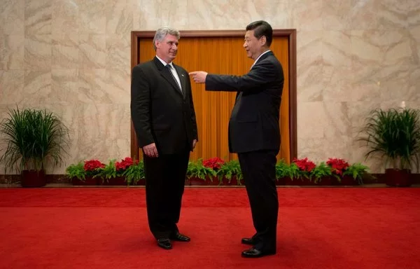 El presidente chino Xi Jinping (derecha) saluda a Miguel Díaz-Canel, entonces vicepresidente primero del Consejo de Estado de Cuba y ahora presidente, en Pekín durante junio de 2013. [Ed Jones/Pool/AFP]