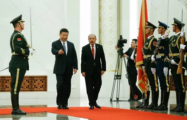 El presidente chino Xi Jinping (izquierda) y el entonces presidente dominicano Danilo Medina asisten a una ceremonia de bienvenida en Pekín en noviembre de 2018. [Thomas Peter/Pool/AFP]