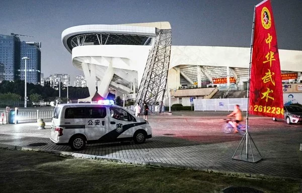 Una patrulla de policía en el Polideportivo de Zhuhai, un día después de que un automóvil embistiera el lugar matando a decenas de personas el 12 de noviembre. [Hector Retamal/AFP]