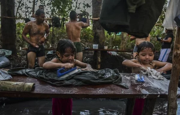 Children of FARC members wash clothes at a camp in Llanos del Yari, Colombia, in September 2016. [Luis Acosta/AFP]