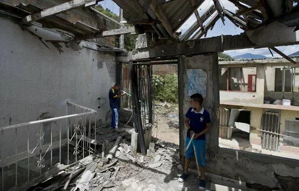 Children play war inside a house destroyed by attacks by FARC targeting the police in El Mango, a rural area in Argelia, Colombia, in June 2015. [Luis Robayo/AFP]