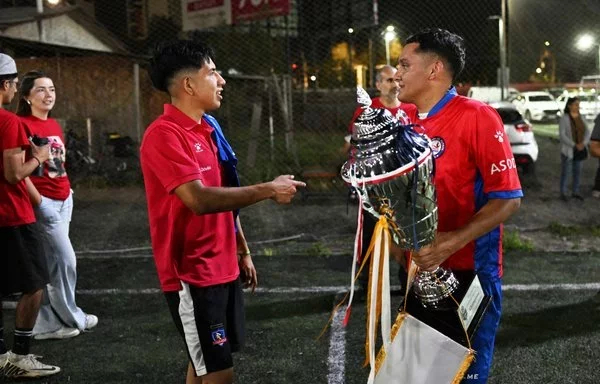 Hector Sanchez (right) and Edison Flores, who received organ transplants, pose with the Transplant Football World Cup trophy during a training session with the Chilean transplant-recipient football team in Santiago. [Rodrigo Arangua/AFP]